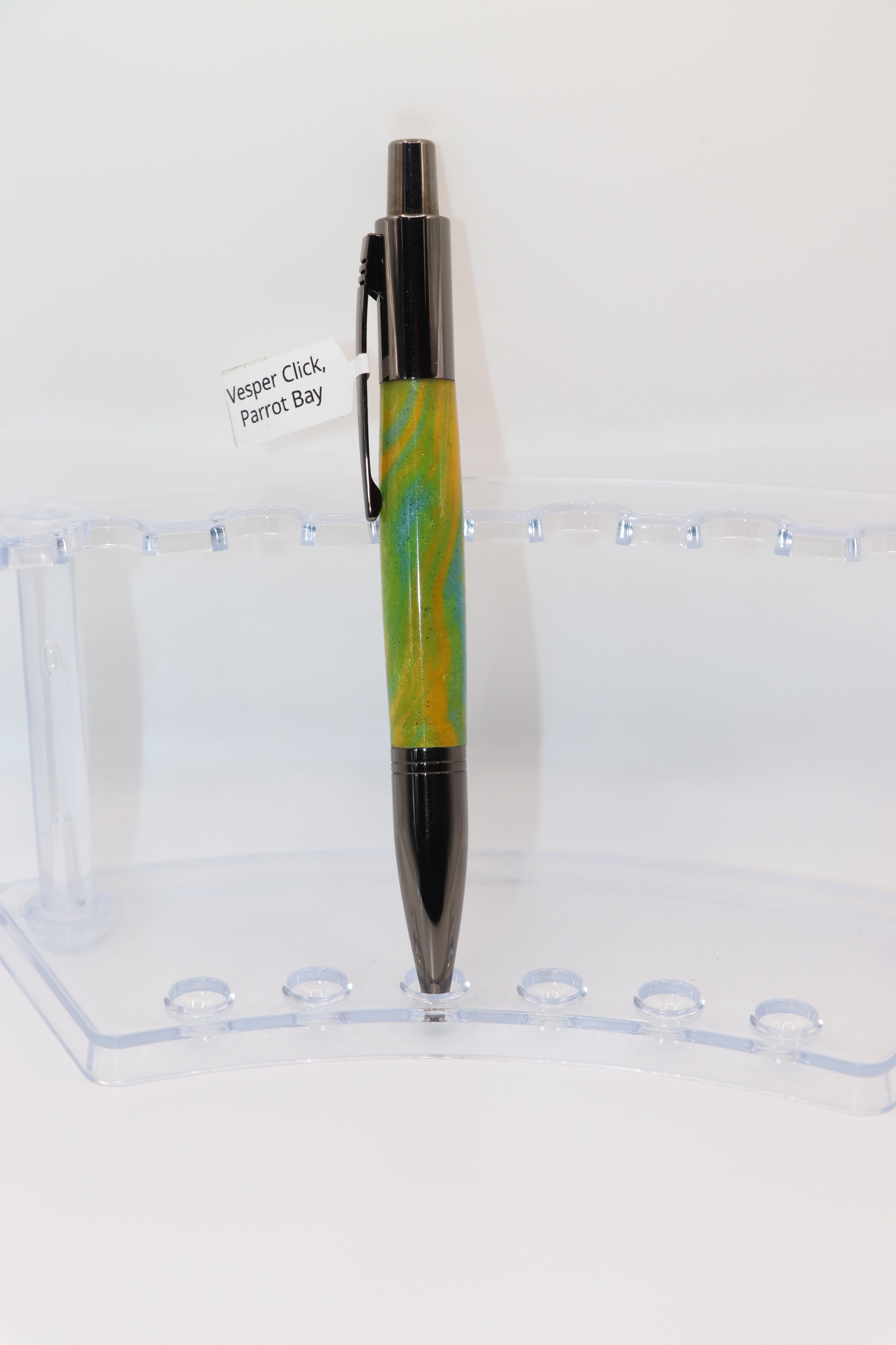Parrot Bay Acrylic:  Pen with yellow and Gun Metal design on a clear stand against a white background